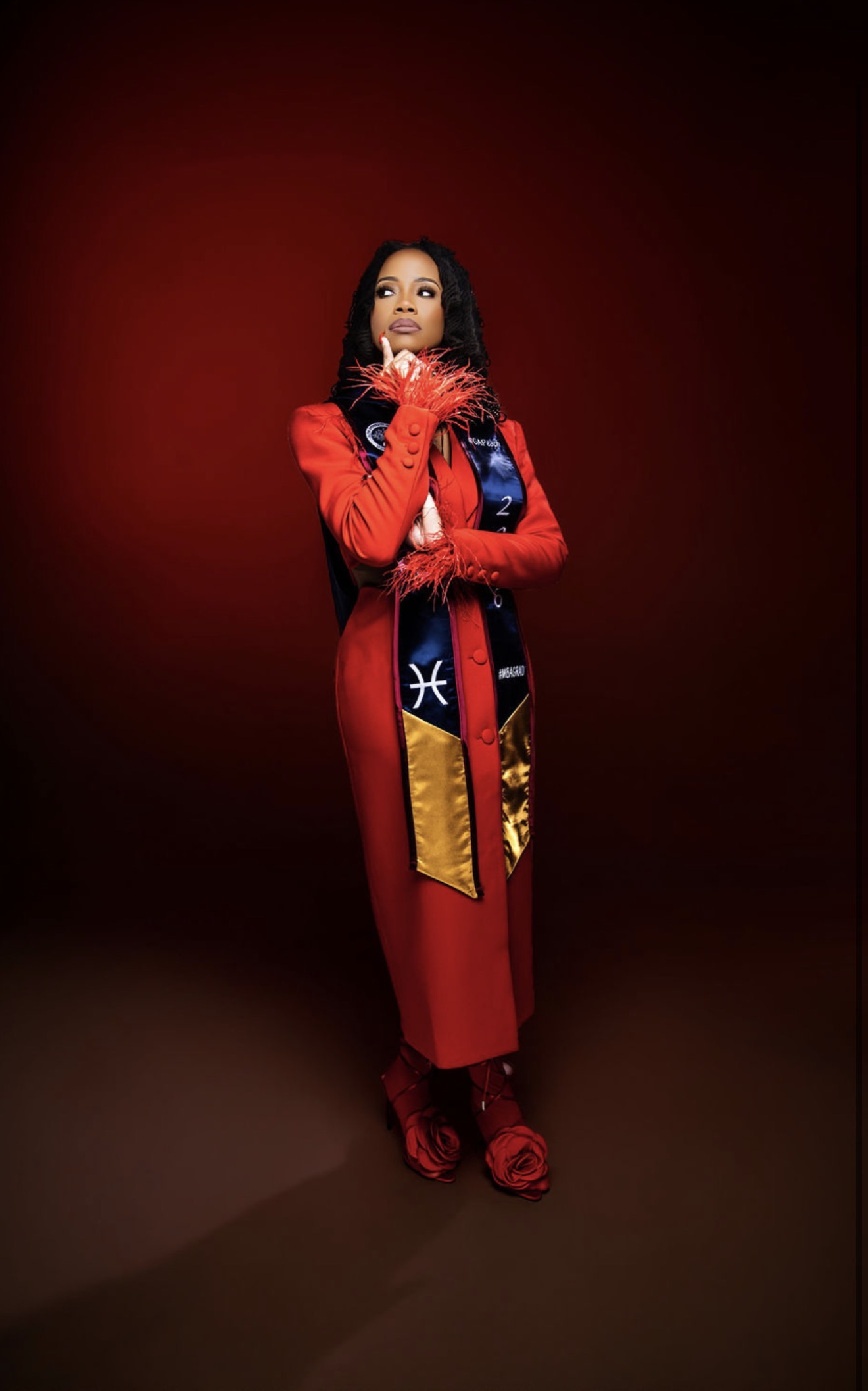 Leonia Moore standing confidently in red academic regalia